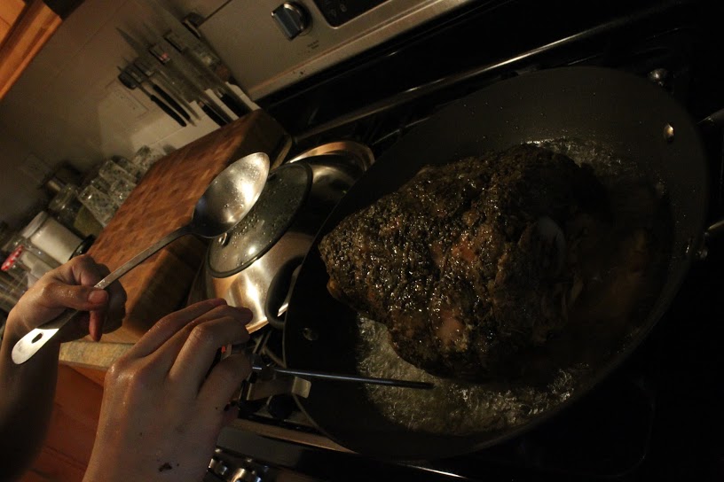 Splattering away. Holding the thermometer while ladling hot oil over the top of the porchetta, as per the recipe. Note that metal candy thermometers get hot as you hold it in boiling oil.